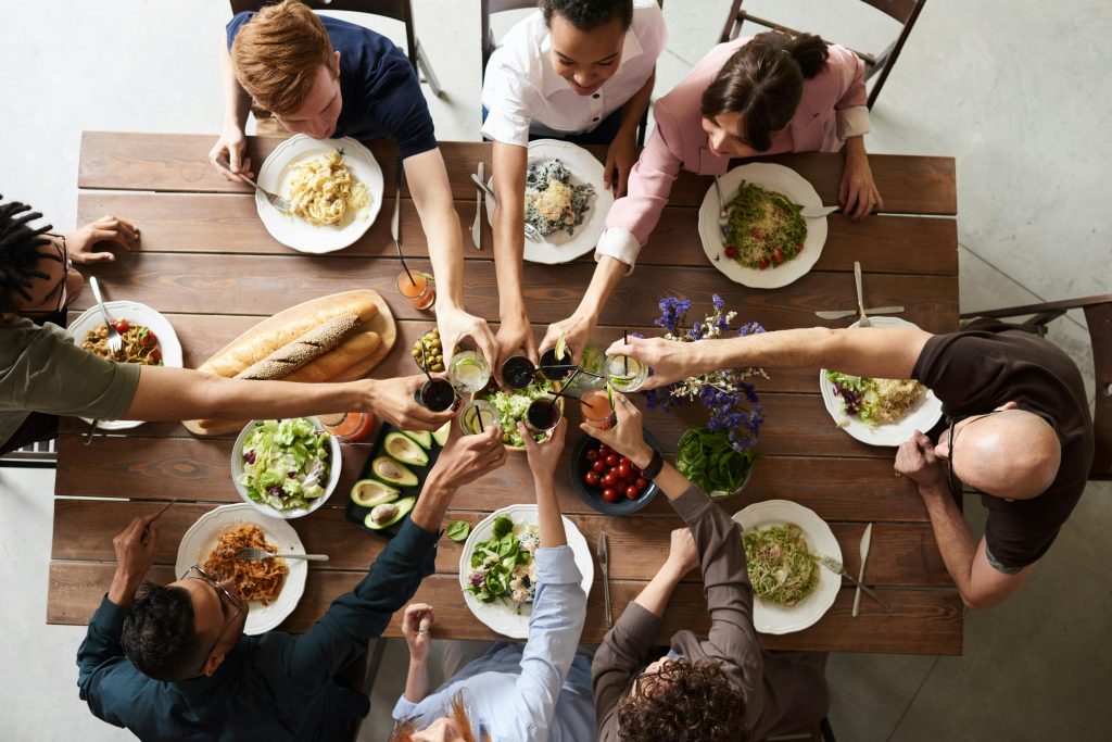 pexels-photo-3184183-3184183 A vibrant group cheers over a delicious meal, showcasing friendship and togetherness.